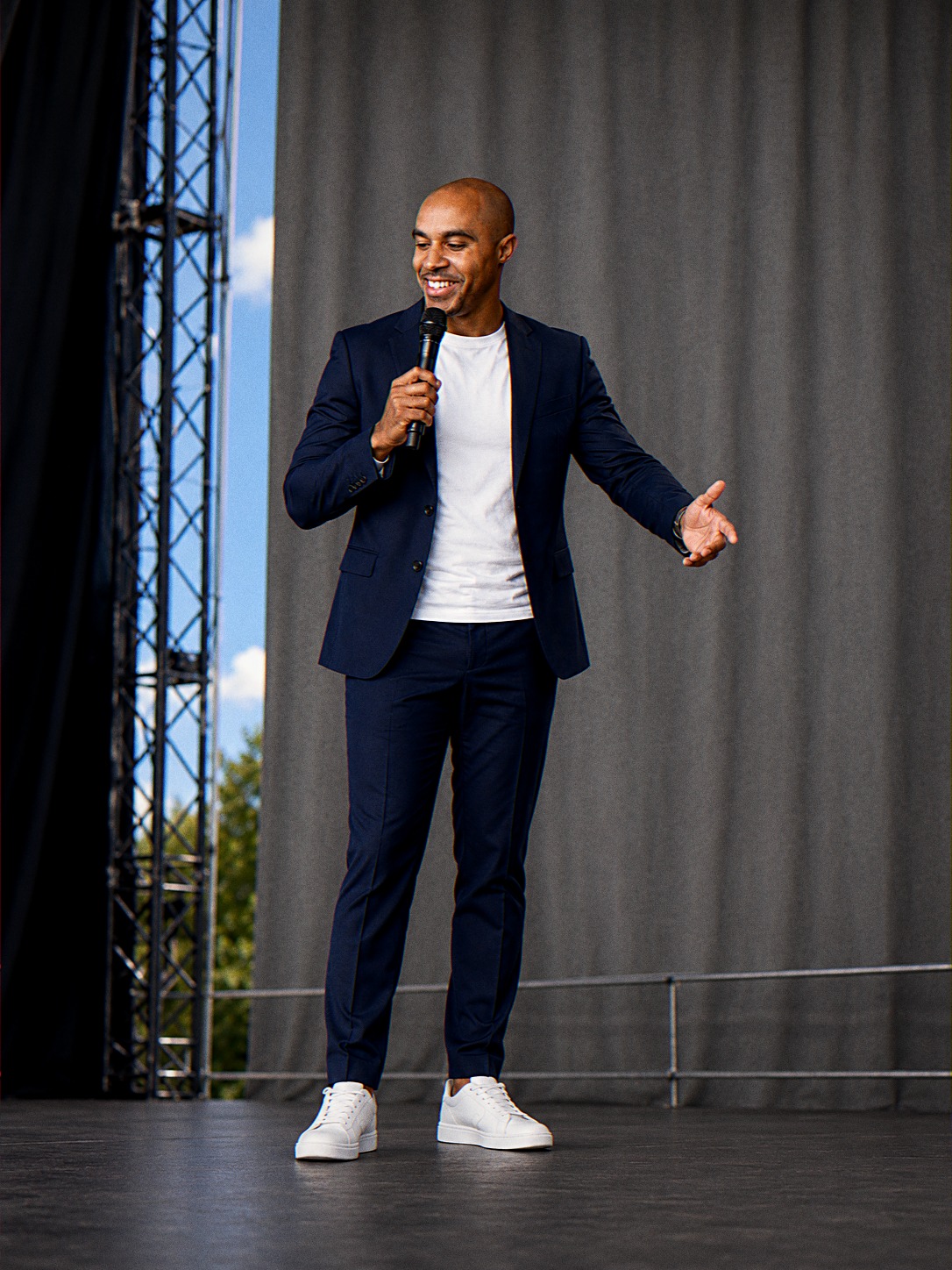 Shaun Benn hosting on an outdoor festival stage with a microphone
